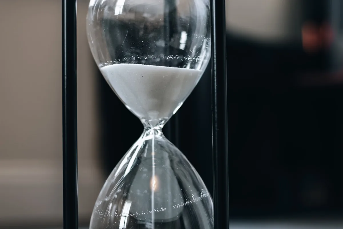 Hourglass on a wooden table — longevity metaphor for all-day wear