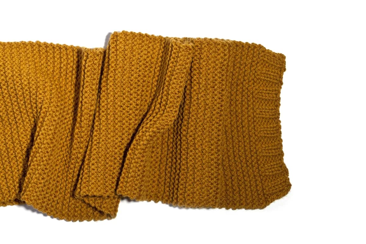 Knitted wool scarf close-up on white background in soft natural light